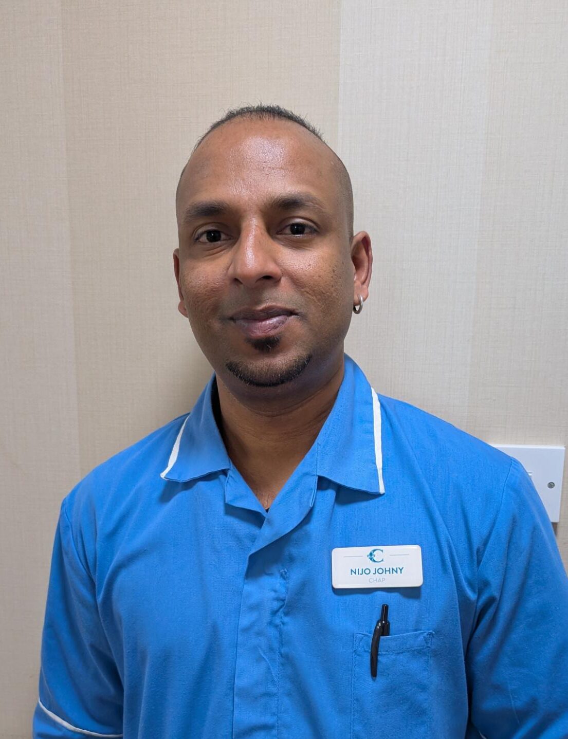 man smiling in blue uniform