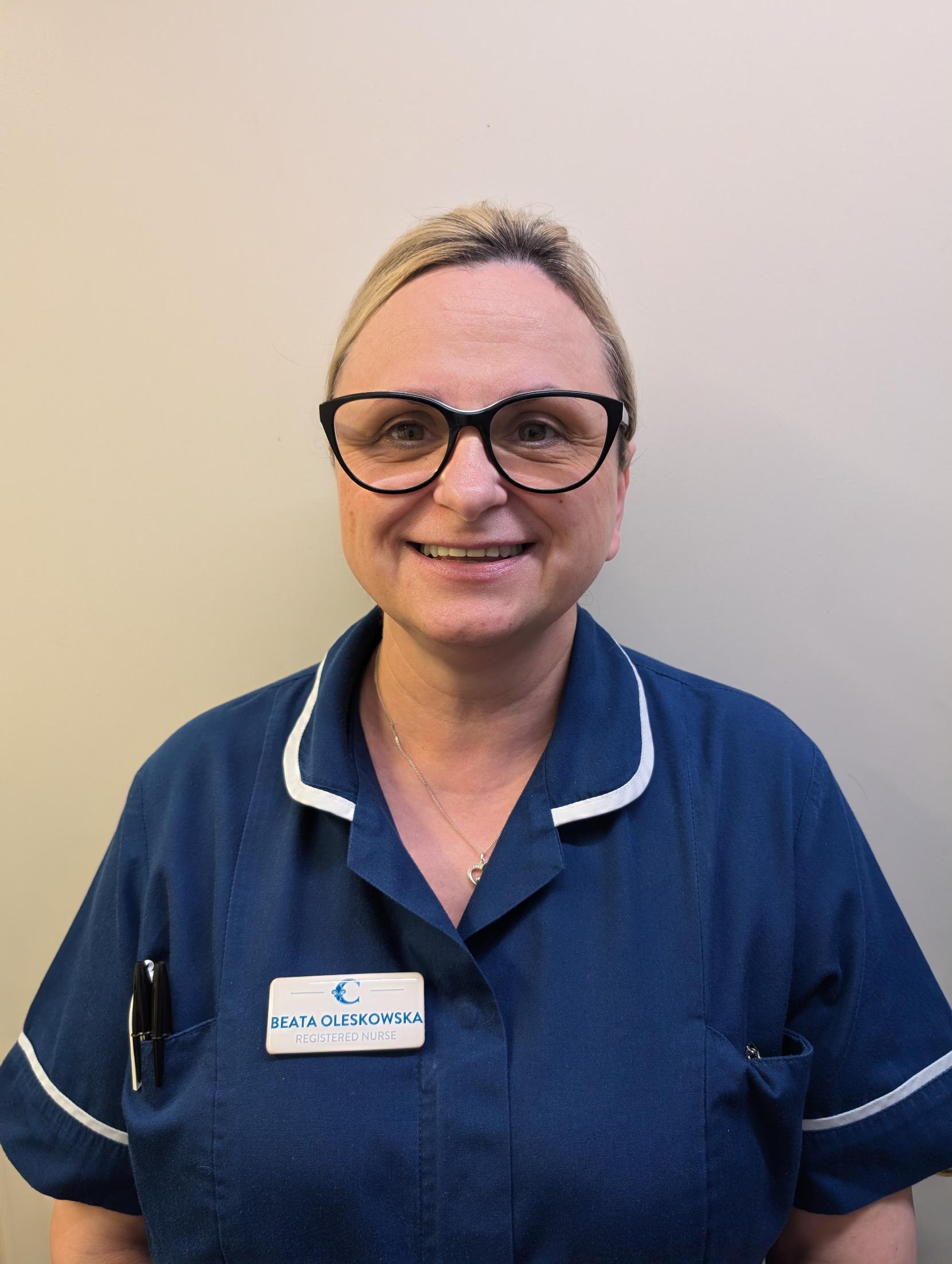 nurse with blonde hair in dark blue uniform