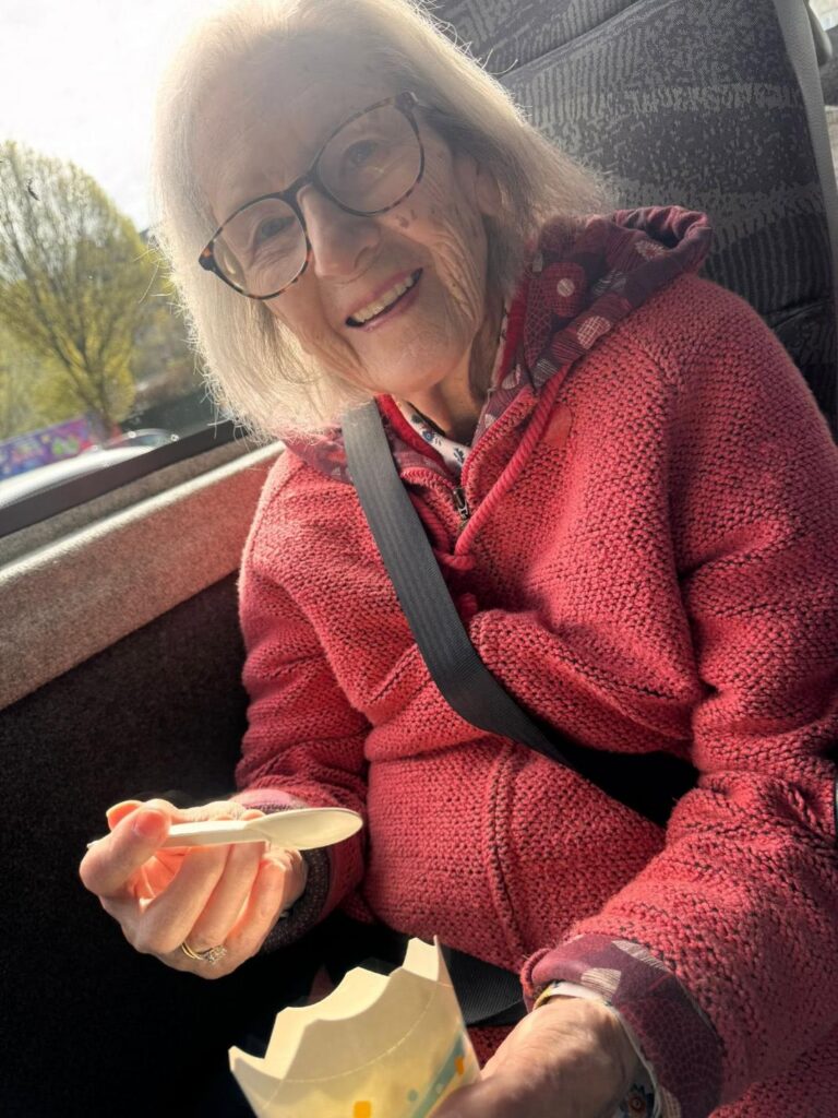 elderly woman enjoying an ice cream on a minibus