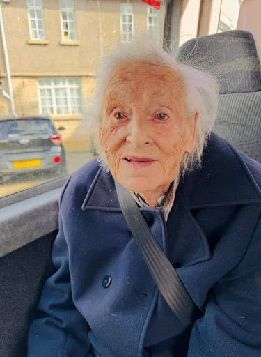 elderly woman smiling in a minibus