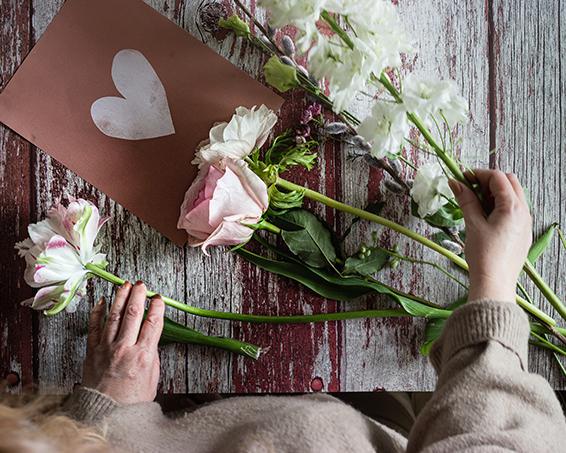 arranging white and pink roses on a table