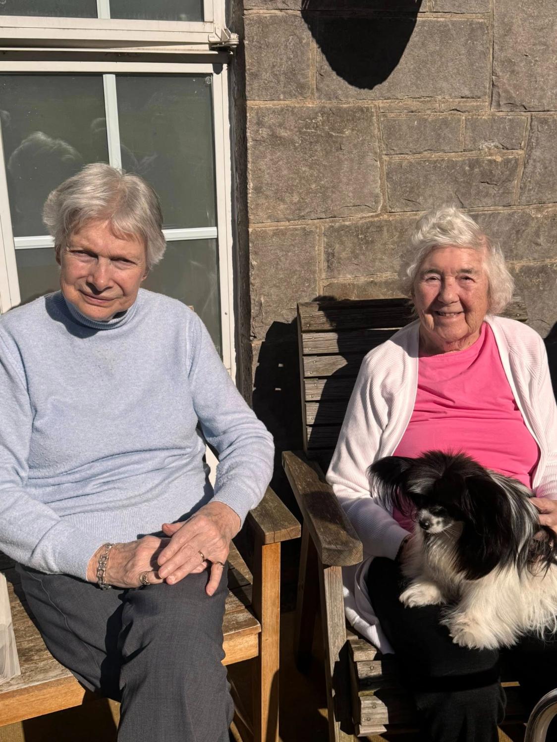 two elderly women smiling in the sunshine