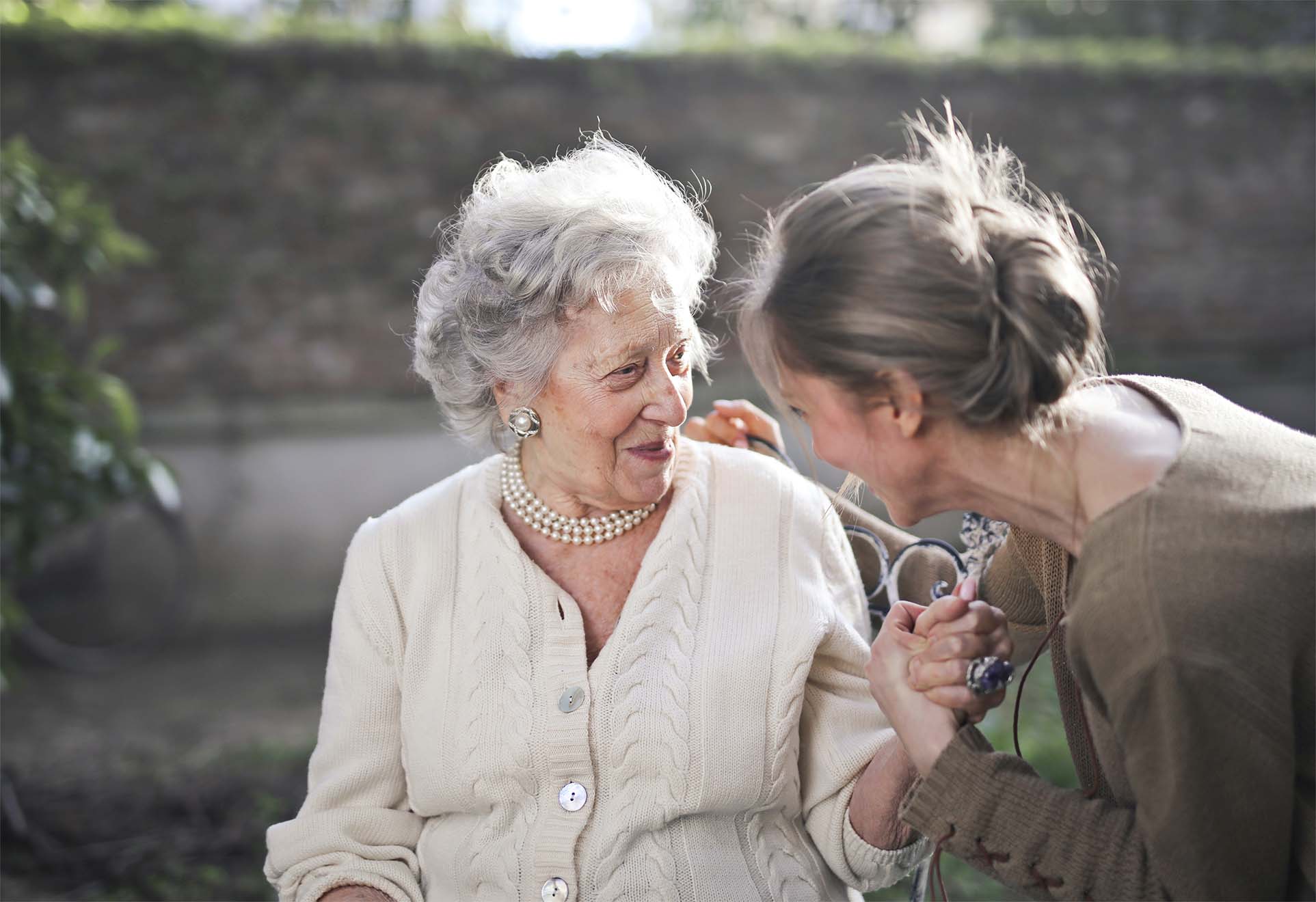 elderly woman smiling with a carer
